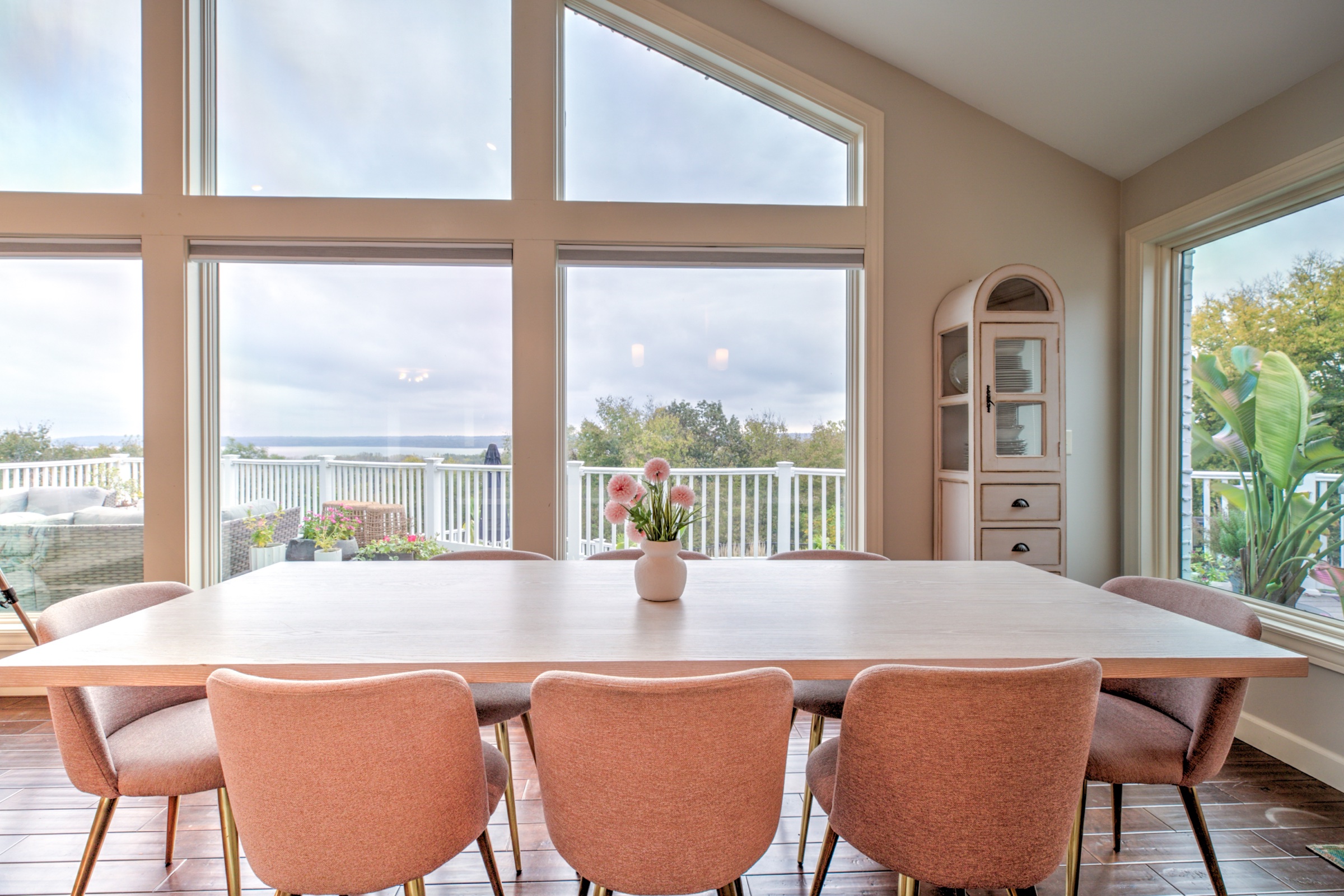 Dining area with seating for eight beside broad windows overlooking the deck and Illinois River Valley