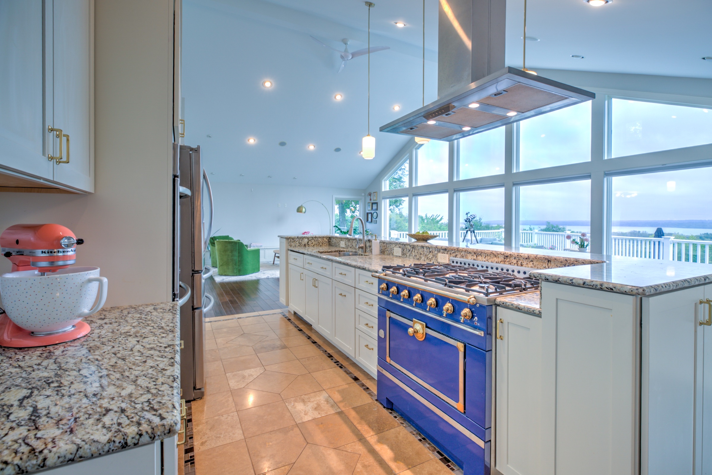 Blue 36 inch La Cornue range with brass details in the open kitchen overlooking the river valley