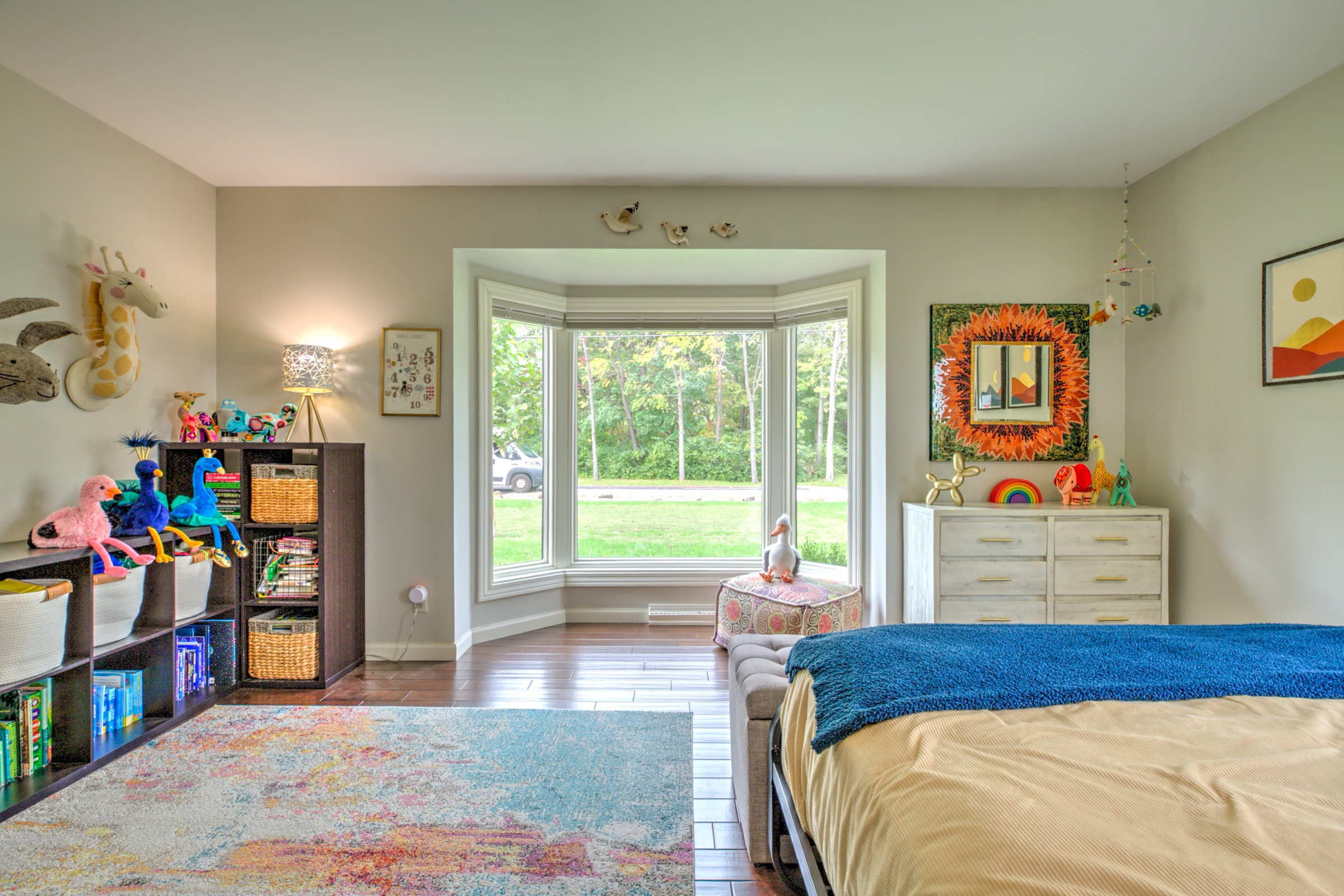 Bedroom with a deep bay window, hardwood flooring, and generous space for sleeping and play