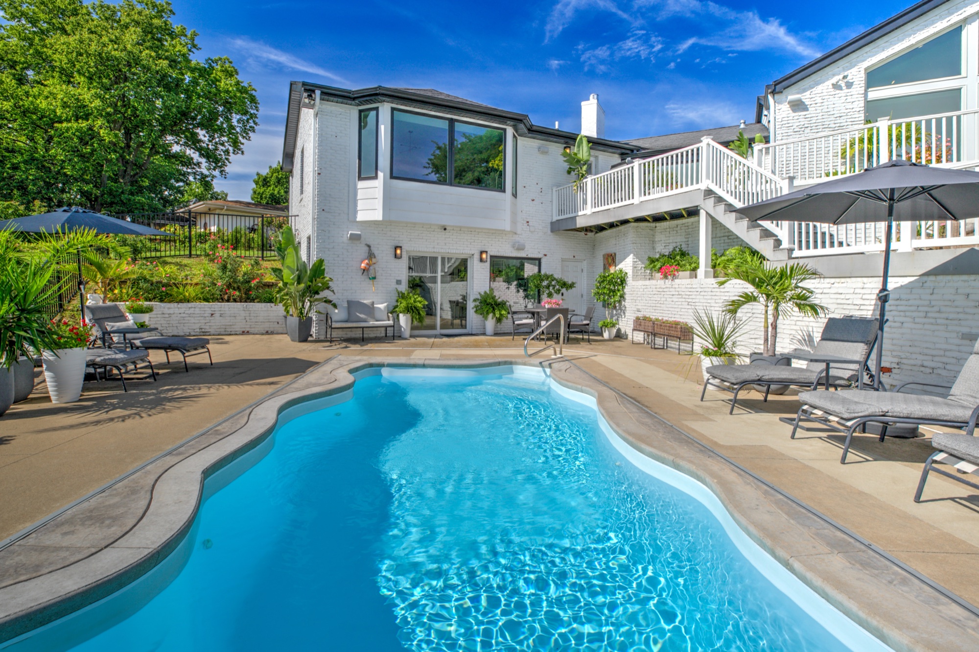 Daytime view across the pool toward the walkout lower level and upper decks