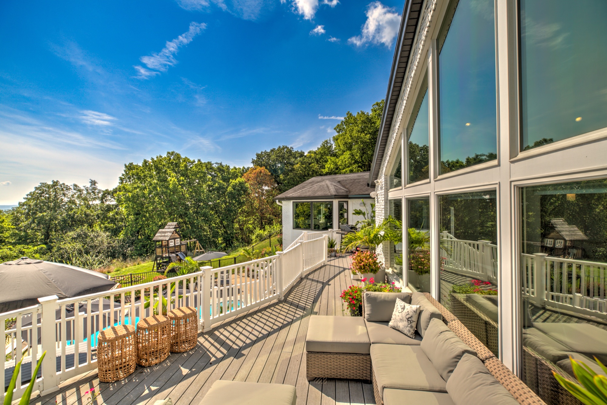 Upper deck seating beside the dramatic east facing wall of windows and wooded bluff setting